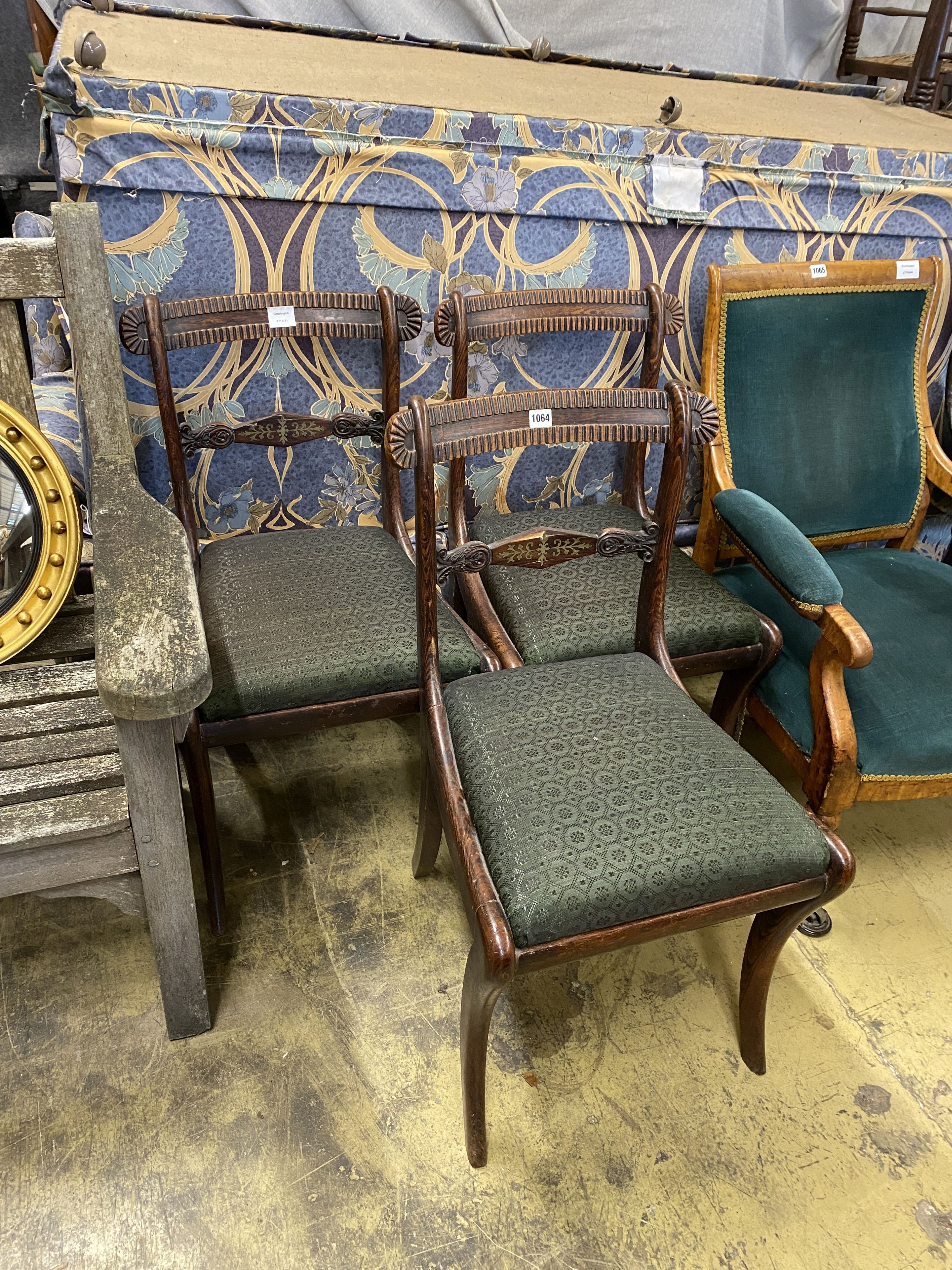 A set of three Regency simulated rosewood dining chairs, with brass-inlaid rails and sabre legs